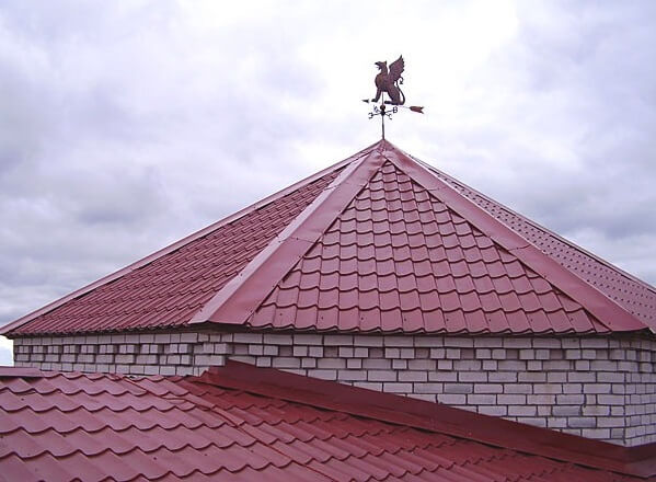 Фото крыши с флюгером, кровлей из металлочерепицы и плоской планкой конька